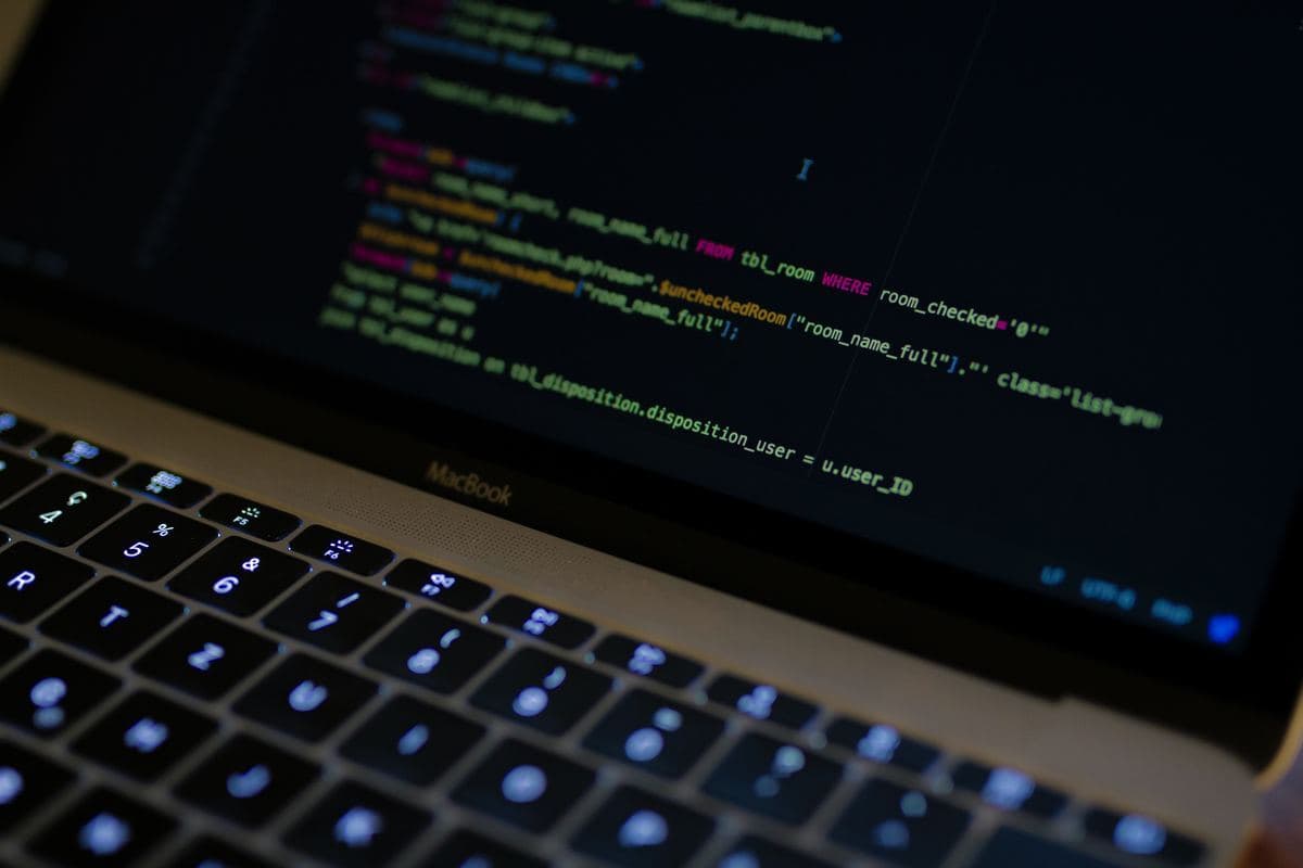 A laptop displaying lines of programming code on its screen, illustrating software development work.